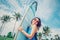 Smiling woman with surfboard posing on tropical beach