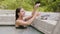 Smiling woman taking bath in thermal pool and applying mud mask on face skin. Beautiful woman in thermal water pool