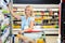 Smiling woman taking food from shelf