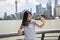 Smiling woman taking selfie while standing by railing against Pudong skyline