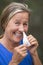 Smiling woman with tissue in running nose