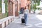 Smiling woman traveller dragging black suitcase luggage bag walking to passenger boarding in airport, Travel concept