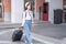 Smiling woman traveller dragging black suitcase luggage bag walking to passenger boarding in airport, Travel concept