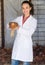 Smiling woman veterinarian holding chicken