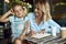 Smiling woman watching her daughter talking on the phone stock photo