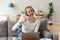 Smiling woman wearing headset showing thumbs up looking at camera