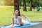 Smiling woman wearing white sports warm up before exercise. Sporty female warming up before running in the public park on