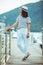 Smiling woman in white standing in dock enjoying the view boats on background