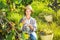 Smiling woman winegrower tasting wine in vineyard