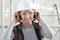 Smiling woman worker portrait wearing helmet, safety glasses and hearing protection headphones, scaffolding interior construction