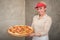 Smiling woman worker selling pizza in fast food restaurant