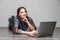 Smiling woman working on laptop on floor