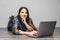 Smiling woman working on laptop on floor