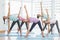 Smiling women doing stretching exercises in fitness studio