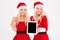 Smiling women in santa cloth showing tablet computer screen