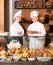 Smiling women selling fresh pastry and loaves