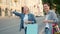 Smiling women with shopping bags hailing taxi waving hand outdoor in city street