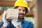 Smiling Worker Carrying Tied Wooden Planks