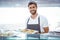 Smiling worker holding pastry behind the counter