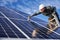 Smiling worker installing solar panel under cloudy sky.