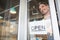 Smiling worker putting up open sign