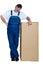 Smiling workman standing by large cardboard box