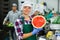 Smiling workwoman of fruit sorting factory standing with half of watermelon