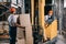 Smiling workwoman sitting in forklift loader