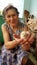 Smiling wrinkled woman portrait with cutie newborn chicken in her hands