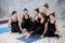 Smiling yogi girl exercising, having a break at class, group of friends watching on the phone