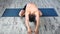 Smiling yogi man professionally practicing yoga exercise on wooden floor indoor