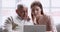 Smiling young adult grown granddaughter teaching old grandfather using laptop