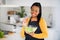 Smiling young african american female chef in apron eating organic vegetable salad, enjoy fresh dish