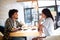 Smiling young african couple sitting at a table at a cafe drinking coffee and talking together