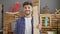 Smiling young arab man at work, professional carpenter confidently handles wood plank in his carpentry studio