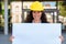 Smiling young architect holding a blank sign