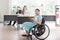 Smiling young Asian woman office worker in wheelchair holding tablet look at camera, disabled people working with colleague