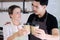 Smiling young barista couple loves Asian man and caucasian woman holding cups of hot coffee together. Start up Coffee shop.