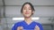 Smiling young and beautiful Asian medical nurse in uniform at hospital prepared to wear a face mask