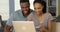 Smiling young black couple using credit card to make online purchases