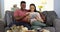 Smiling young black couple using tablet on couch