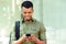 Smiling young black man with smart phone and backpack