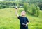 Smiling young boy preparing to launch RC plane. Beautiful nature background.