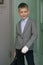 Smiling young boy in a school uniform with hand bandaged