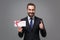 Smiling young business man in classic black suit shirt tie posing isolated on grey background. Achievement career wealth