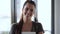 Smiling young business woman looking at camera while standing in the office