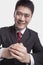 Smiling young businessman with hands clasped together bowing toward camera, studio shot