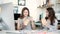 Smiling young businesswomen having lunch at table in office