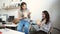 Smiling young businesswomen having lunch at table in office