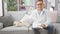 Smiling young caucasian man doubling as home vet, sitting on sofa, holding clipboard, administering pet care to adorable dog